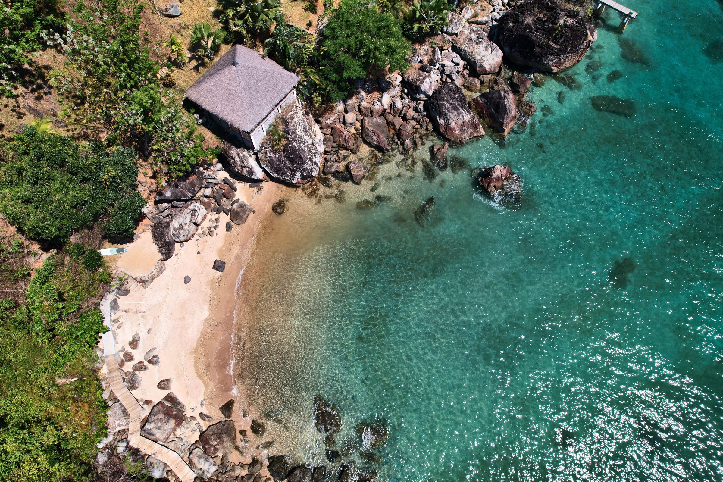 Le bungalow Achille sur son rocher, au-dessus de la crique et du lagon, vu du ciel